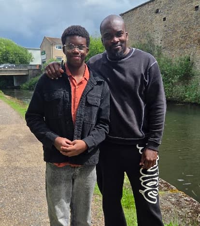Father and son standing together beside a canal during a family visit, showing how parenting from afar is strengthened through quality time, shared moments, and meaningful reunions.