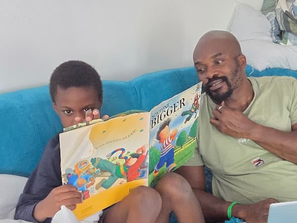 Father and son reading a book about money finances, budgeting saving and preparing for the future